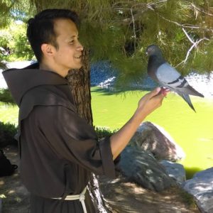 Br. Sam Nasada, OFM, gently called a wild bird to his hand at the Japanases Friendship Garden during a "Care of Creation" outing last year, while serving his pastoral year at St. Mary’s Basilica. He professed Solemn Vows Aug. 20. (Photo courtesy of St. Mary’s Basilica)