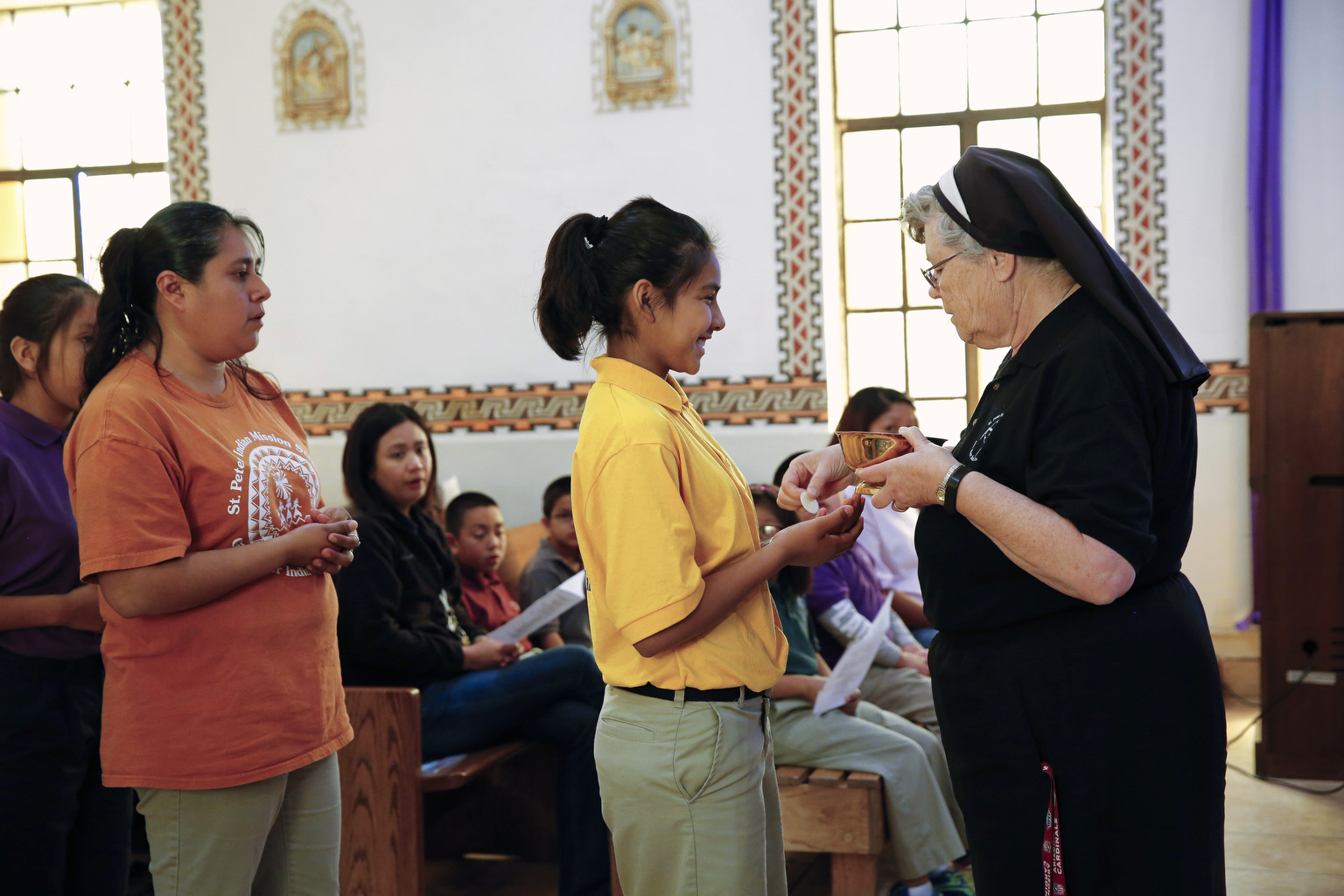 Sr. Carol Mathe distributes Communion during a weekday Mass at St. Peter Indian Mission School in Bapchule, Ariz. The mission church is the center of the school's campus and at the heart of the ministry of the Franciscan Sisters of Christian Charity. (CNS photo/Nancy Wiechec)