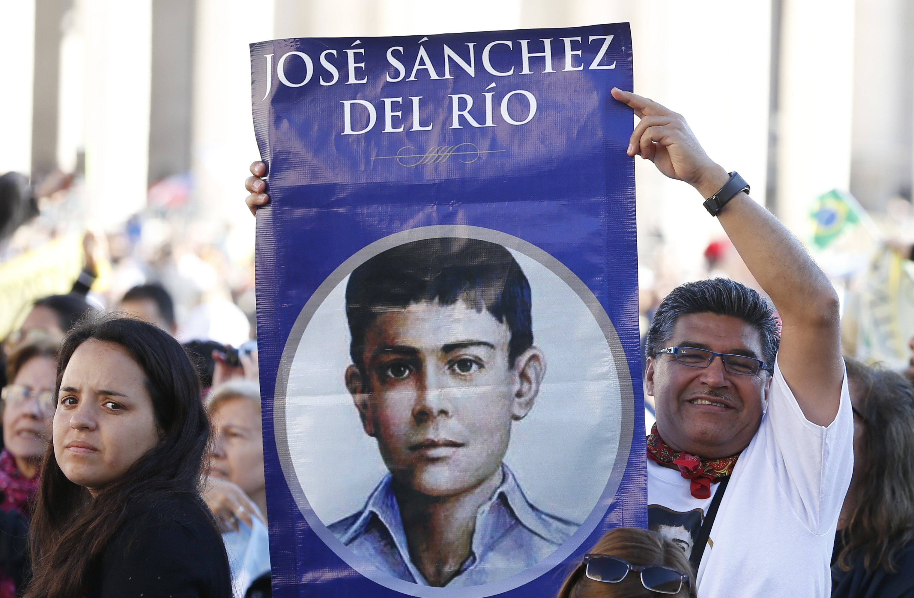 A man holds an image of new Mexican St. Jose Sanchez del Rio, who was martyred at the age of 14 in 1928, before the canonization Mass for seven new saints celebrated by Pope Francis in St. Peter's Square at the Vatican Oct. 16. (CNS photo/Paul Haring)