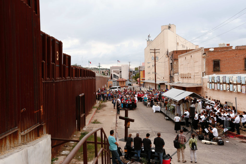 People gather for Mass at the international border in Nogales, Ariz., Oct. 23. The liturgy held on both sides of the border was concelebrated by Archbishop Christophe Pierre, apostolic nuncio to the United States, and the bishops of Tucson, Ariz., and Nogales, Sonora. (CNS photo/Nancy Wiechec) 