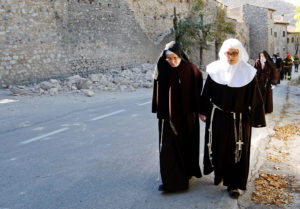 Nuns walk next to a partially collapsed wall Oct. 30 following an earthquake in Norcia, Italy. Thousands of people in central Italy have spent the night in cars, tents and temporary shelters following the fourth earthquake in the area in three months.(CNS photo/Remo Casilli, Reuters)