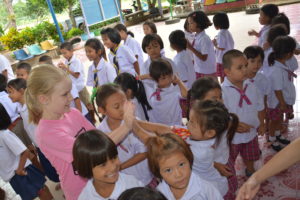 Bailey Rasmussen (SSJ ‘20) high-fives kids in Thailand after donating supplies to a local school (courtesy photo)