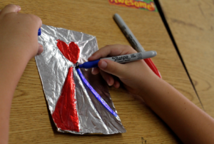 A first-grader at Our Lady of Mount Carmel works on his Divine Mercy art project Sept. 29. (Ambria Hammel/CATHOLIC SUN)