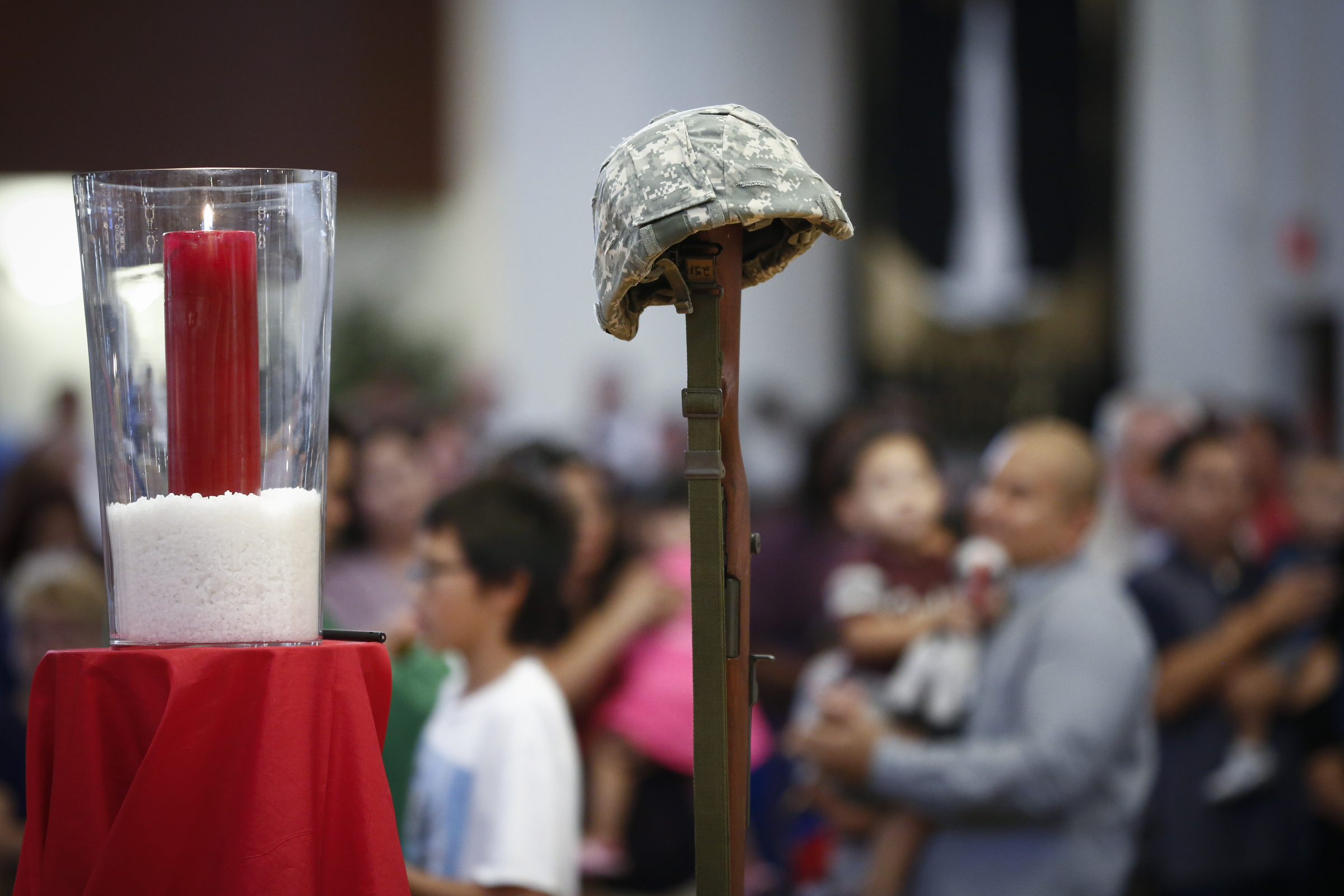 A military helmet rests on a rifle during the sixth annual Red, White and Blue Mass at St. Thomas Aquinas Church in Avondale, Ariz., Nov. 6. During the Mass, the Diocese of Phoenix honored active and retired service men and women and those who have died in service to the country. Veterans Day is Nov. 11. (CNS photo/Nancy Wiechec)