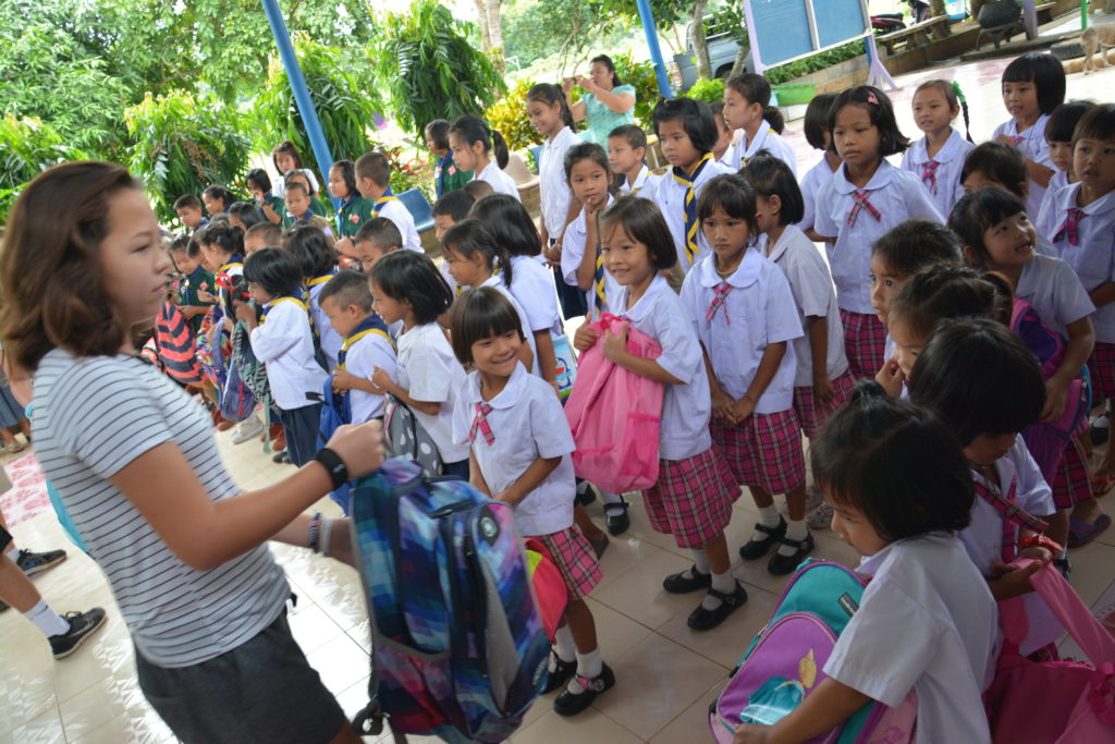 Regan Williamson, an eighth-grader at Ss. Simon and Jude, distributes backpacks to kids in need in Thailand. (courtesy photo)