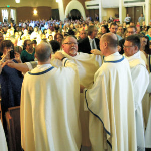 Priests and deacons of the diocese vest Dcn. Chris Giannola during his ordination Mass Nov. 5. (Ambria Hammel/CATHOLIC SUN)