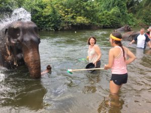 Kathy Prebil, a Xavier mom and alumna, and Lauren Prebil, a Xavier junior and Ss. Simon and Jude graduate, bathe an injured elephant in Thailand. (courtesy photo)