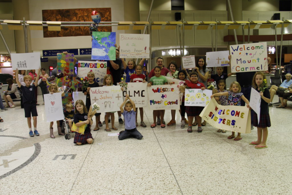 Children from Our Lady of Mount Carmel School and parish practice holding up their welcome signs at Sky Harbor International Airport Oct. 28. Classrooms made them and personal cards in anticipation of the arrival of Servants of the Plan of God, a religious community based in Peru. (Ambria Hammel/CATHOLIC SUN)