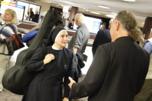 One of the Servants of the Plan of God greets Fr. John Bonavitacola, pastor at Our Lady of Mount Carmel, following the sisters' arrival at Sky Harbor International Airport Oct. 28. (Ambria Hammel/CATHOLIC SUN)