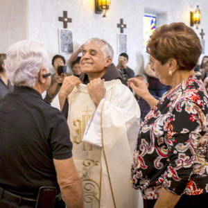 Family members help Fr. Louis Khoury, OFM, vest for the first time. (Billy Hardiman/CATHOLIC SUN)