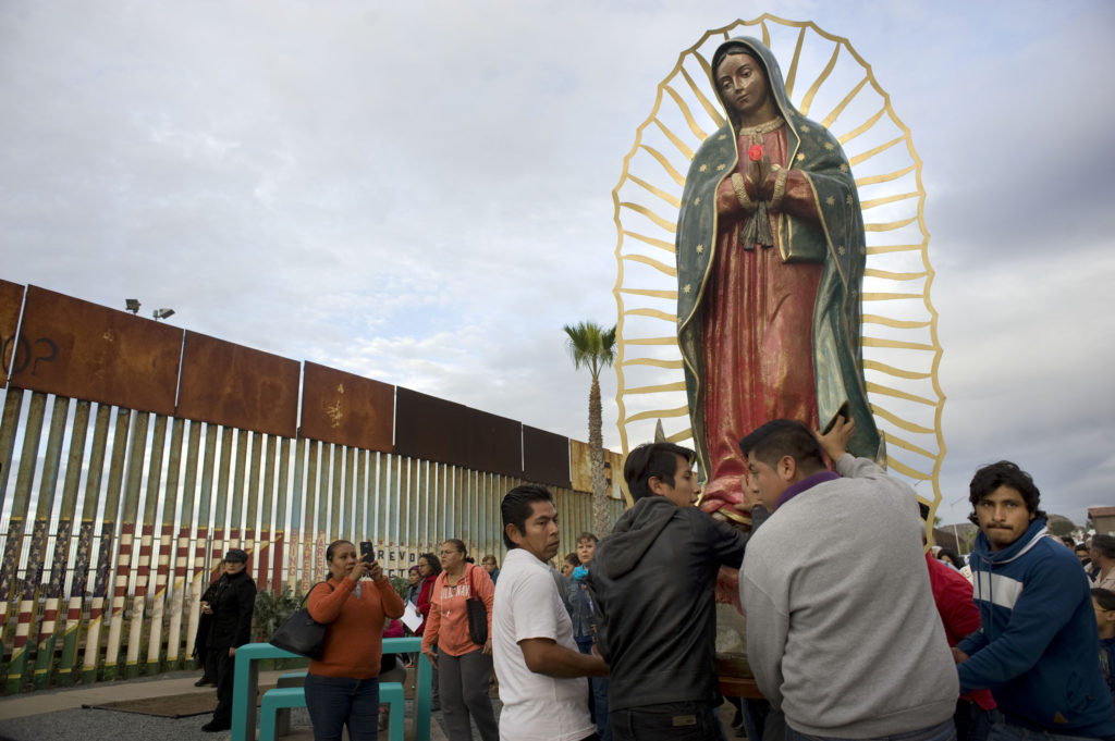 A statue of Our Lady of Guadalupe is unloaded from a truck after a Nov. 19 procession to the U.S.-Mexico border fence in Tijuana, Mexico, where Mass was celebrated. The Mass and a procession with a statue of Our Lady of Guadalupe were a call to remember and pray for migrants and were led by Archbishop Francisco Moreno Barron of Tijuana. (CNS photo/David Maung)