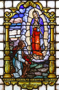 The appearance of Mary to indigenous peasant St. Juan Diego in 1531 near present-day Mexico City is depicted in a stained-glass window at St. Mary Church in Manhasset, N.Y. The feast of St. Juan Diego is celebrated Dec. 9, three days before the feast of Our Lady of Guadalupe, Dec. 12. (CNS photo/Gregory A. Shemitz) 