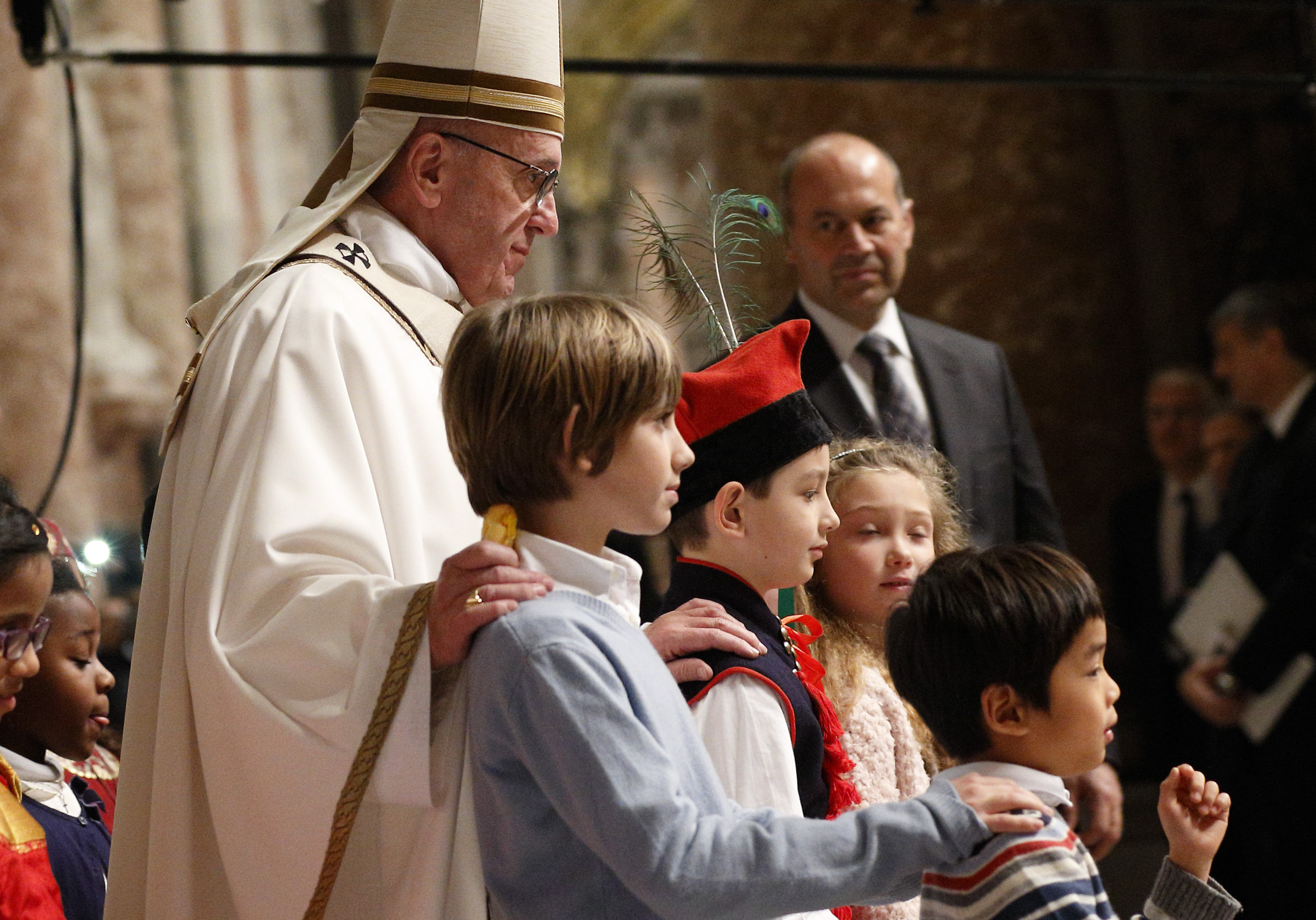 Pope Francis walks with children at the conclusion of Christmas Eve Mass in Peter's Basilica at the Vatican Dec. 24. (CNS photo/Paul Haring)
