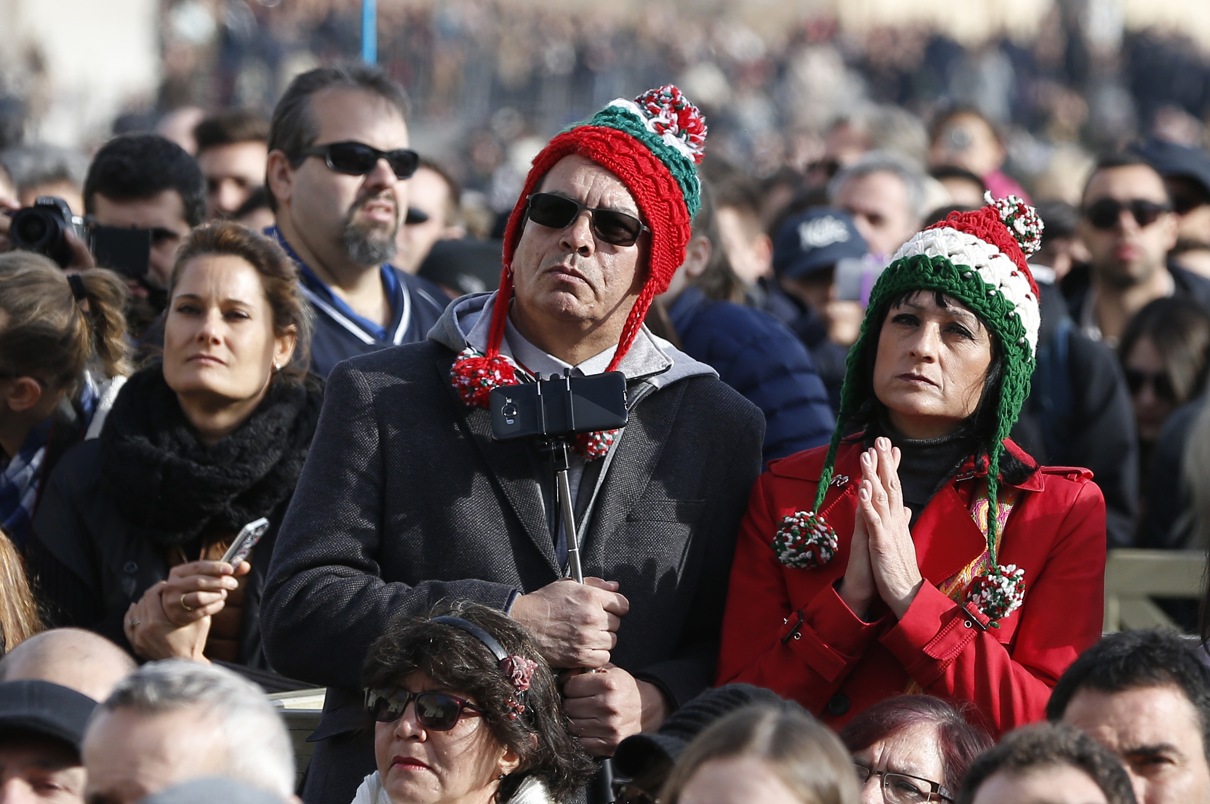 People watch as Pope Francis delivers his Christmas message and blessing "urbi et orbi" (to the city and the world) from the central balcony of St. Peter's Basilica at the Vatican Dec. 25. (CNS photo/Paul Haring)