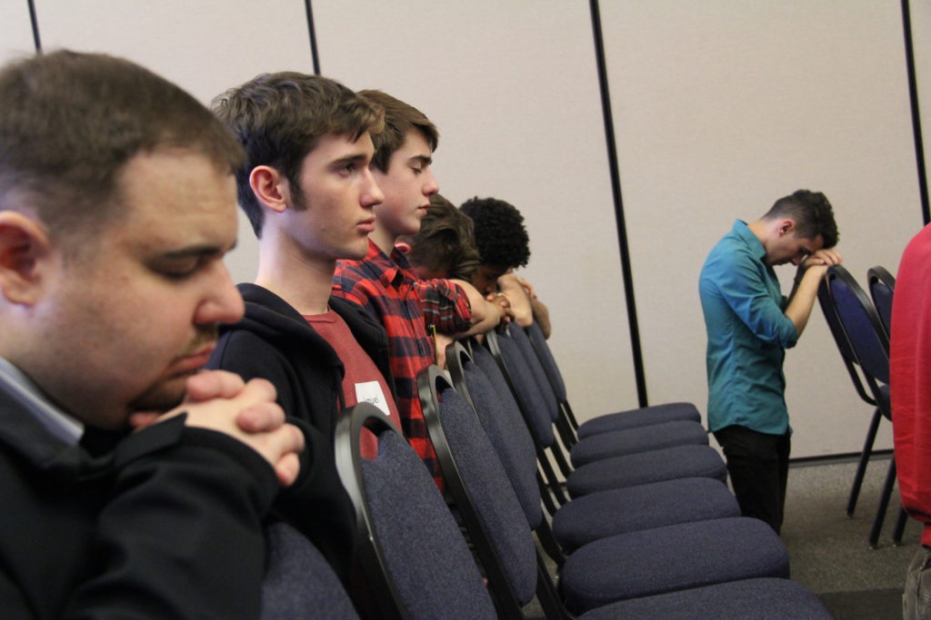 More than 200 high school teenagers and college students kneel in prayer during the first Young Men's Conference held in January this year. The next one will be Dec. 30 at St. Bernadette in Scottsdale. (Catholic Sun file photo) 